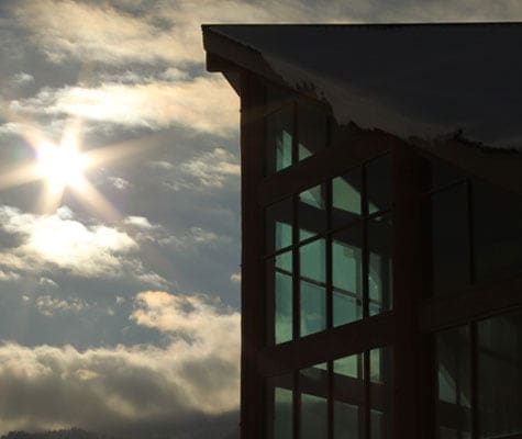 A view of the summit of the triangular shaped roof of the Stanford Fernie Resort against the darkening skies of evening.
